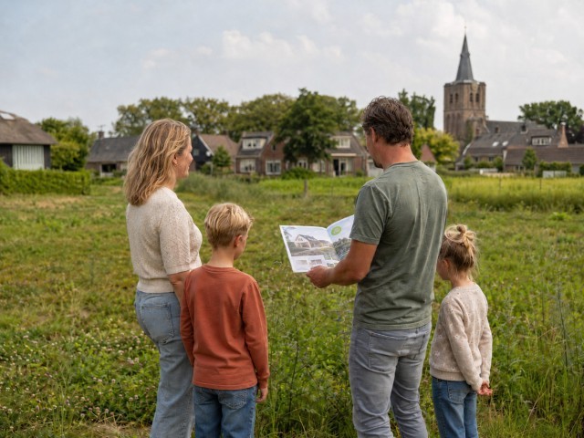 Woningezoekenden_Met verkoopbrochure kijkend naar stuk grond.jpg